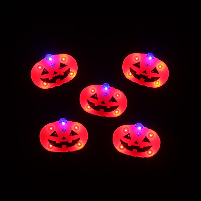 Five glowing jack-o'-lantern lights with red and blue LEDs arranged against a black background. Each pumpkin features a carved face with triangular eyes and a toothy grin.