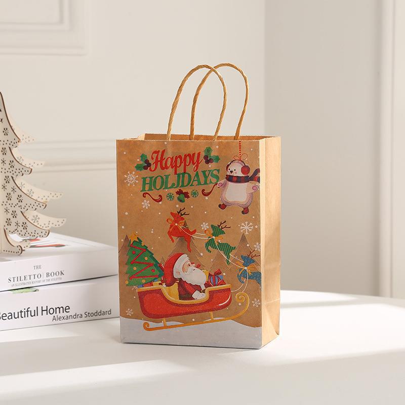 Festive gift bag with Santa in sleigh, reindeer, and "Happy Holidays" text, on a light background next to books and a decorative tree.