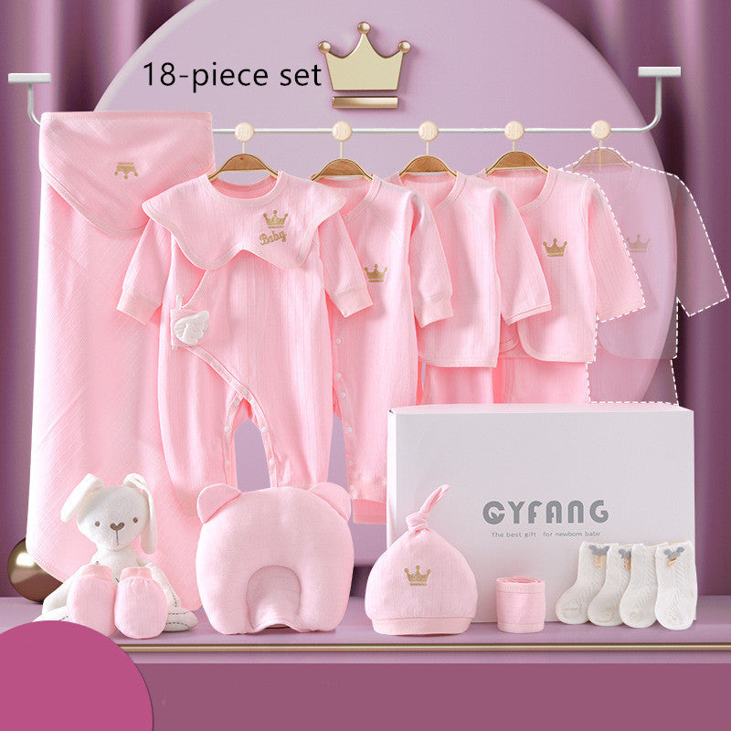 Pink 18-piece baby clothing set includes onesies, bibs, mittens, blanket, socks, and a stuffed bunny, all with crown motifs. Displayed on hangers with branded box.