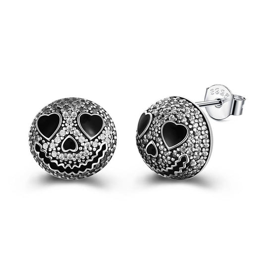 Black and silver skull earrings with heart-shaped eyes and textured detailing, featuring a cheerful smile and stud backings.