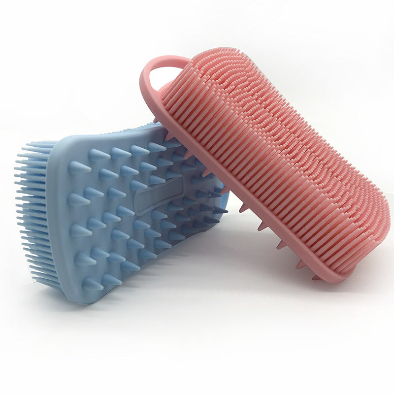 Two silicone massage scrubbers, one pink and one blue, with soft bristles and handles, designed for gentle exfoliation and massage, displayed on a white background.