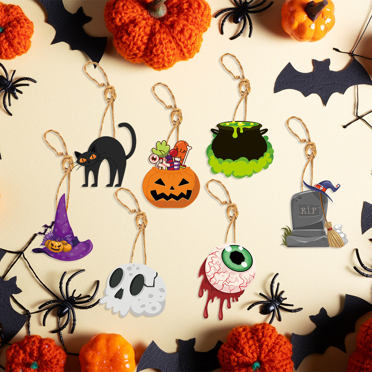 A Halloween-themed image featuring hanging decorations, including a black cat, jack-o'-lantern, cauldron, witch hat, skull, eyeball, and gravestone. The background is adorned with orange pumpkins, black spiders, and bats, creating a festive and spooky atmosphere.