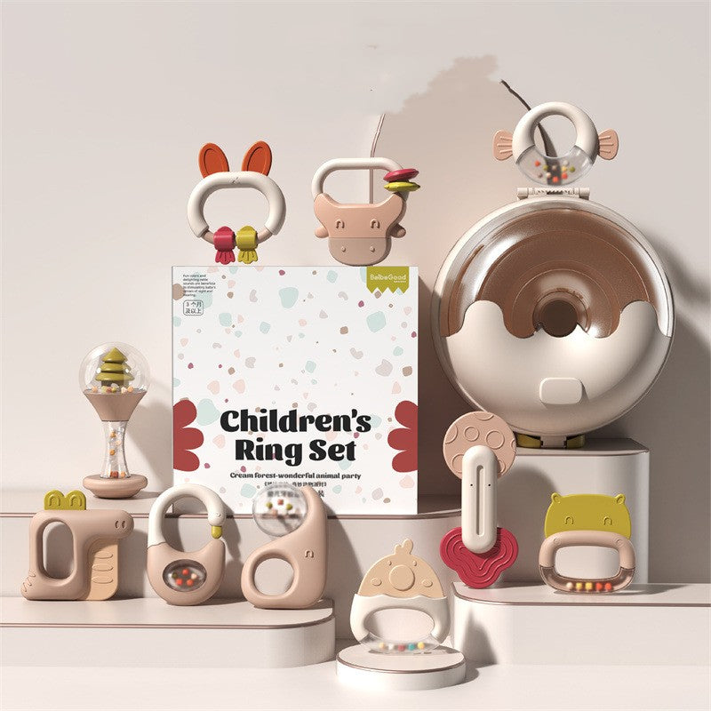 Children's ring set with various pastel-toned animal-themed teething toys. Displayed on white platforms, the packaging features colorful patterns and the title "Children's Ring Set."