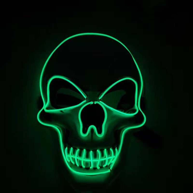 A glowing green neon skull on a black background, featuring prominent eye sockets and teeth, creating a stark, eerie effect.