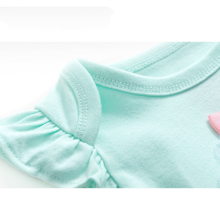 Close-up of a light blue t-shirt featuring a round neckline and short ruffled sleeves. A hint of a pink detail is visible on the right side.