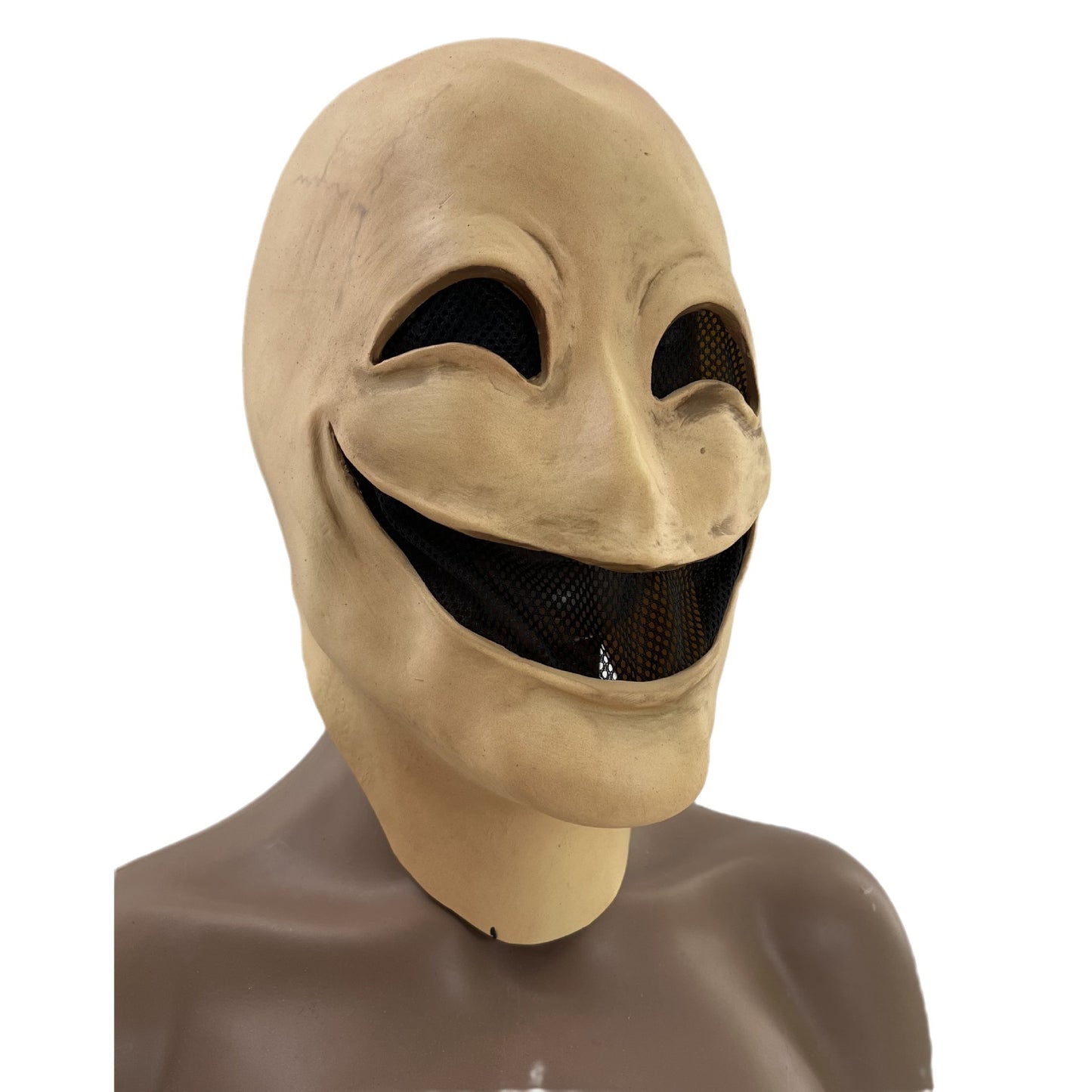 Smiling beige mask with exaggerated features, large eye holes with mesh, and an open grin, displayed on a mannequin bust against a plain white background.