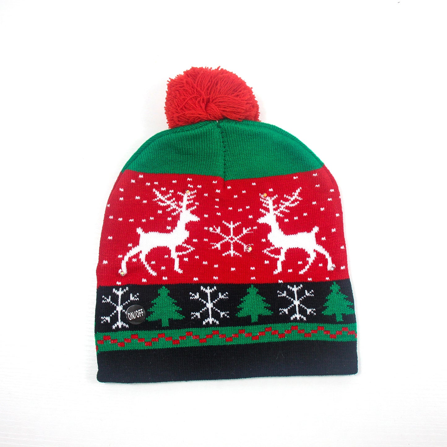 Green and red beanie with a red pom-pom, featuring white reindeer, snowflakes, and green trees on a black band. Holiday-themed design on a white background.
