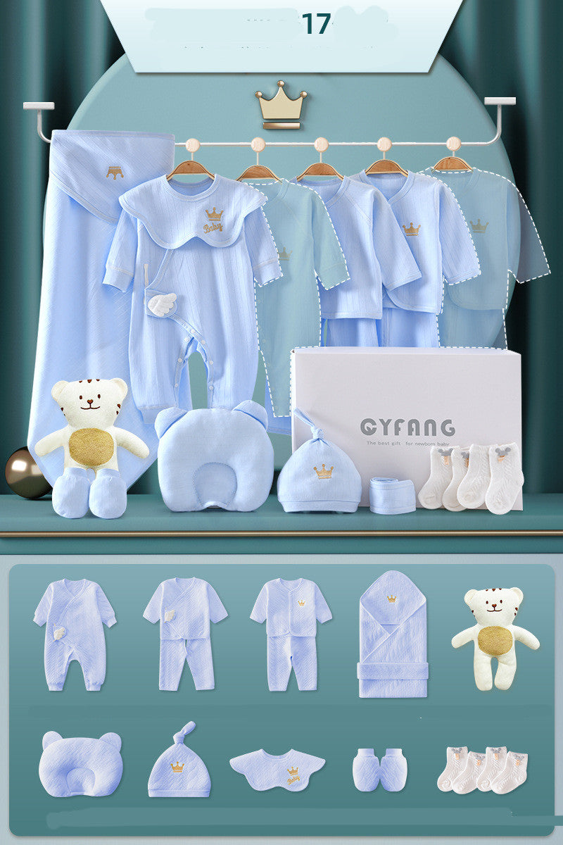 Baby gift set with blue clothing and accessories, including bodysuits, a blanket, cap, socks, teddy bear, neck pillow, and gift box, all featuring crown and baby motifs.