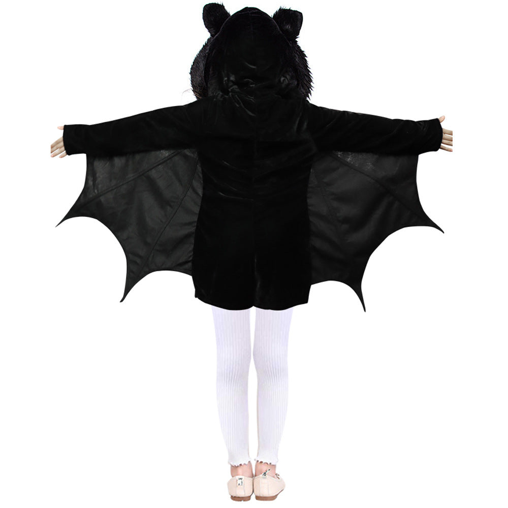 Child wearing a black bat costume with wings extended, viewed from the back. The outfit includes a hood with ears, and the child is in white tights and shoes.