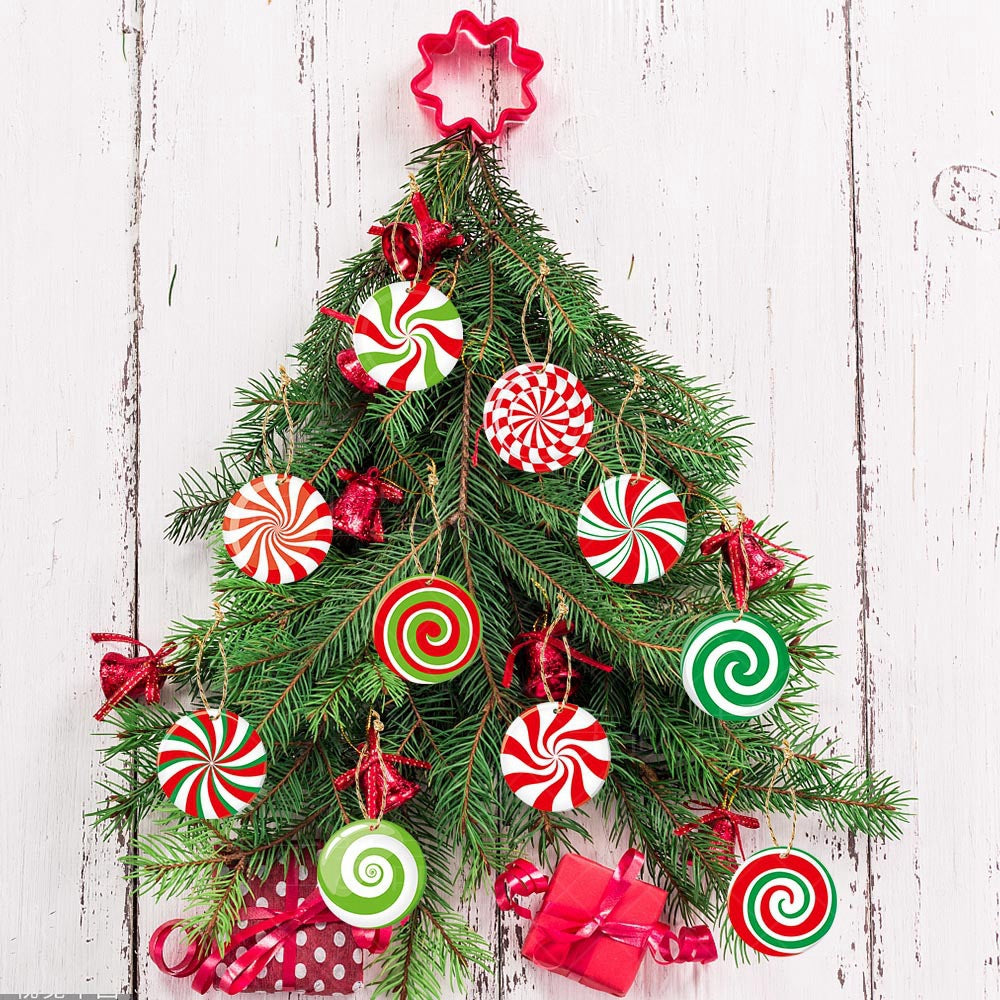 Festive Christmas tree made of pine branches on a wooden background, decorated with colorful swirled candy ornaments and red bows, topped with a star-shaped cutter.