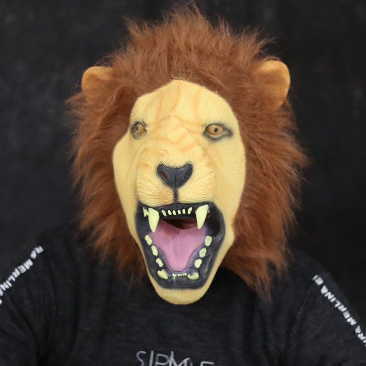 Person wearing a realistic lion mask with a fierce expression and open mouth. The mane is shaggy, and the teeth are prominently visible. Black background.