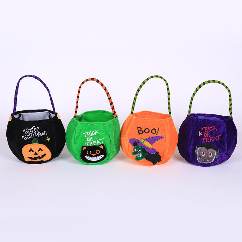Four colorful Halloween bags with handles. Designs include a pumpkin, black cat, witch, and vampire, each labeled with themed phrases like "Trick or Treat" and "Boo!"