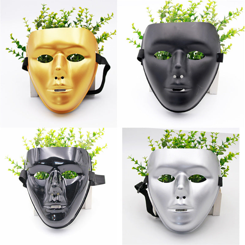 Four planter pots styled as masks in gold, black, glossy black, and silver, with green foliage emerging from the top, displayed on a white background.