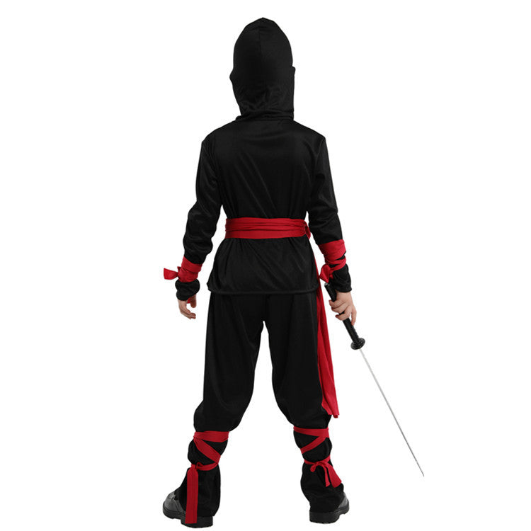 A child in a black ninja costume with red accents stands facing away, holding a sword. The outfit includes a hood, red belt, and red wraps on arms and legs.