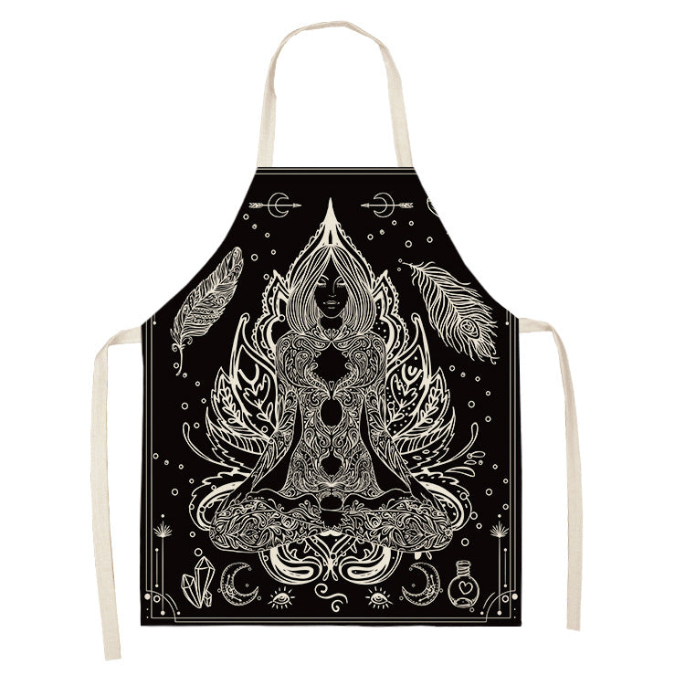 Black apron featuring intricate white line art of a meditating figure surrounded by feathers, moons, and crystal motifs, creating a mystical and serene design.