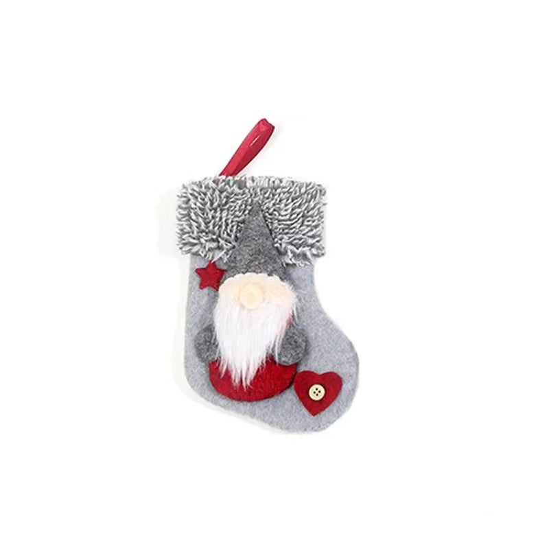 Gray Christmas stocking with a fluffy trim and a felt gnome design. The gnome has a red hat and heart detail. A red loop at the top allows it to hang.
