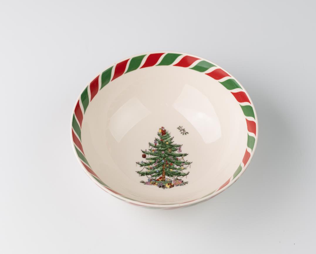 Cream-colored bowl with a festive Christmas tree inside, surrounded by gifts. The rim features a red and green striped pattern, resembling candy canes.