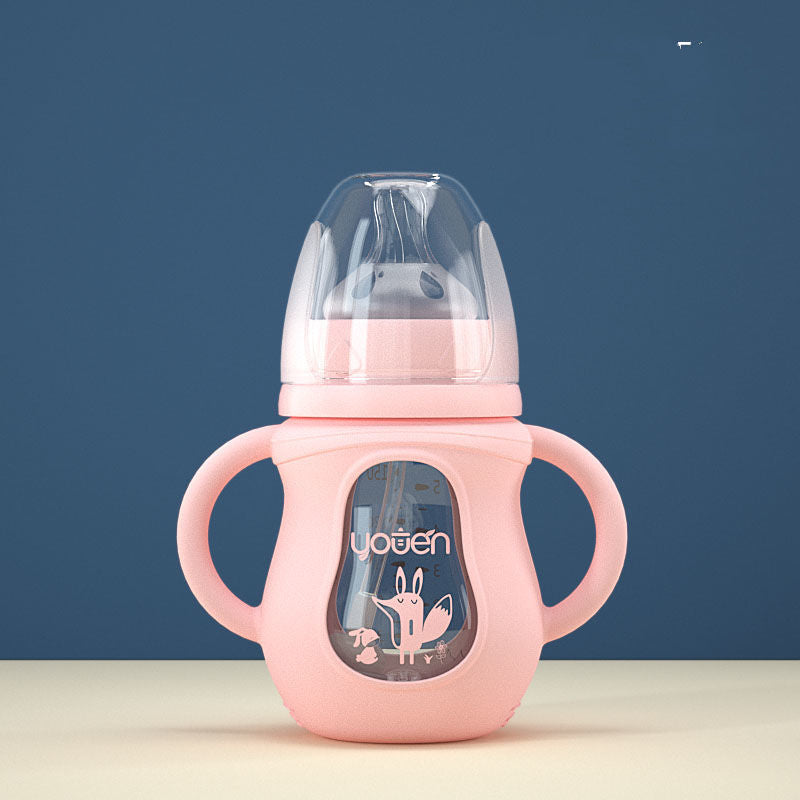Pink baby sippy cup with dual handles and a clear lid, featuring a cute cartoon fox design on the front. Sits on a cream surface against a blue background.