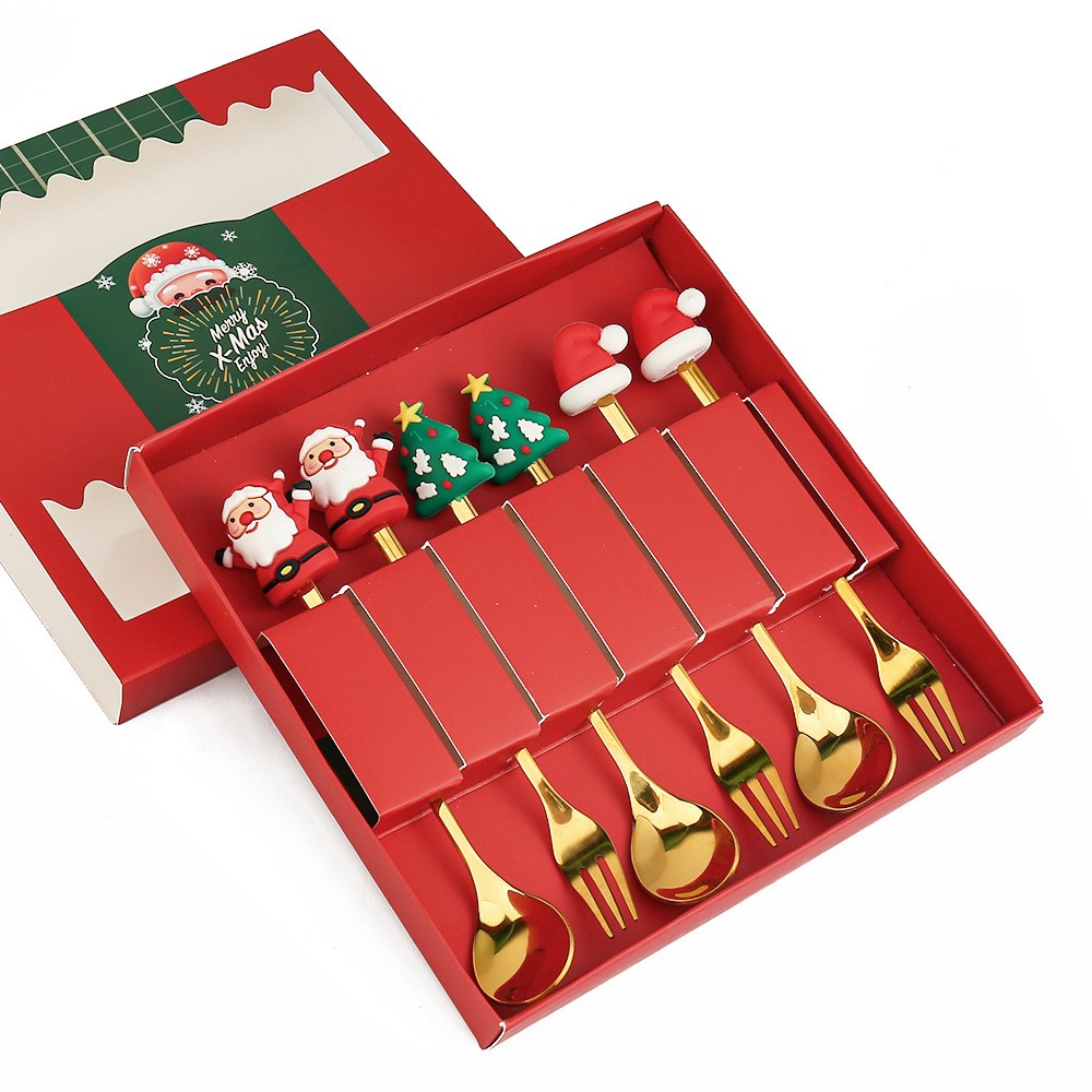 Red gift box with a festive fork and spoon set. Handles feature holiday icons like Santa, Christmas trees, and hats. Includes gold utensils for a holiday celebration.