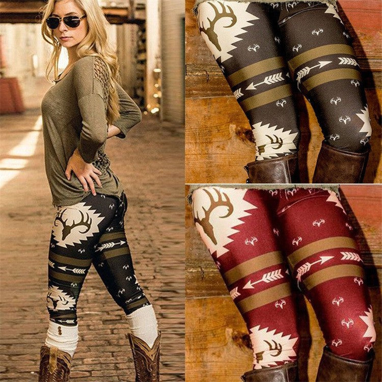 Woman wearing patterned leggings with deer and arrow motifs, paired with a green top and boots. Inset shows leggings in two colors: brown and dark red.