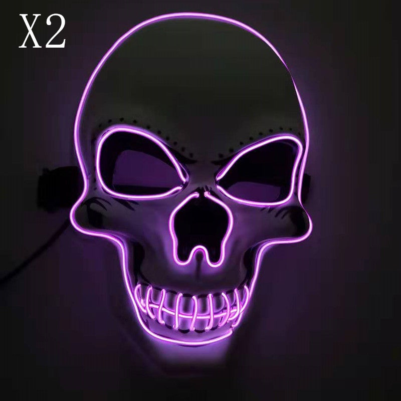 Glowing skull mask with bright pink outlines, dark eye sockets, and prominent teeth on a black background. The upper left corner shows "X2" in white text.