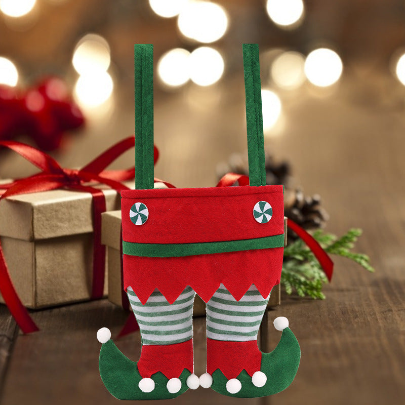 Festive elf-themed gift bag with red and green colors resembling elf legs and striped pants. Background features wrapped gifts and soft holiday lights for a cozy atmosphere.