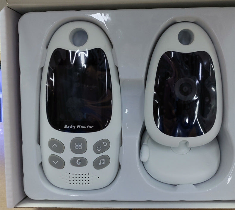 A boxed baby monitor set with two white devices. The left device features a screen and control buttons, while the right device has a circular camera lens.