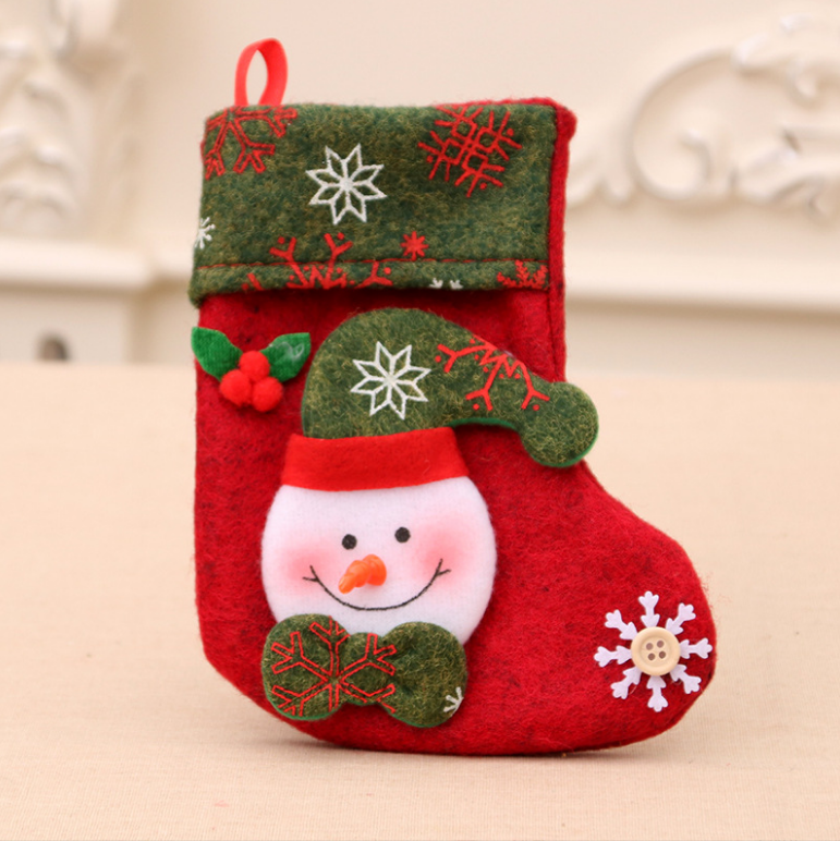 Red Christmas stocking with a green cuff features a snowman design, decorated with snowflakes and a holly sprig. A button accent forms the center of a large snowflake.