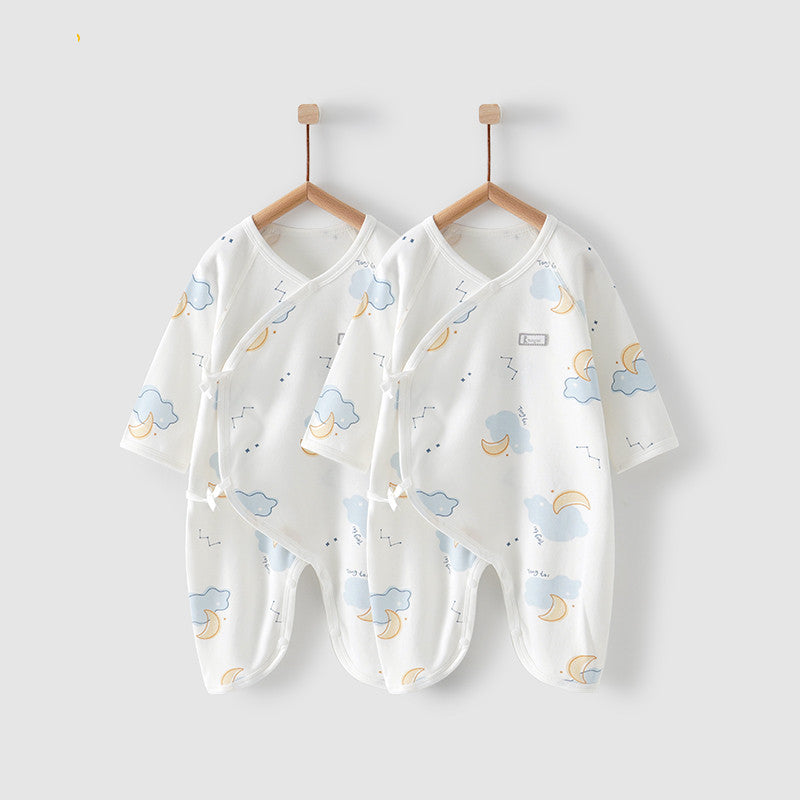 Two white baby onesies with pastel cloud and moon patterns hang on wooden hangers against a light background. The onesies feature side snap closures.