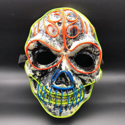 Colorful skull mask with orange, blue, and neon yellow wire patterns on a black and white base, featuring hollow eyes and a grinning mouth. Black adjustable strap on the back.
