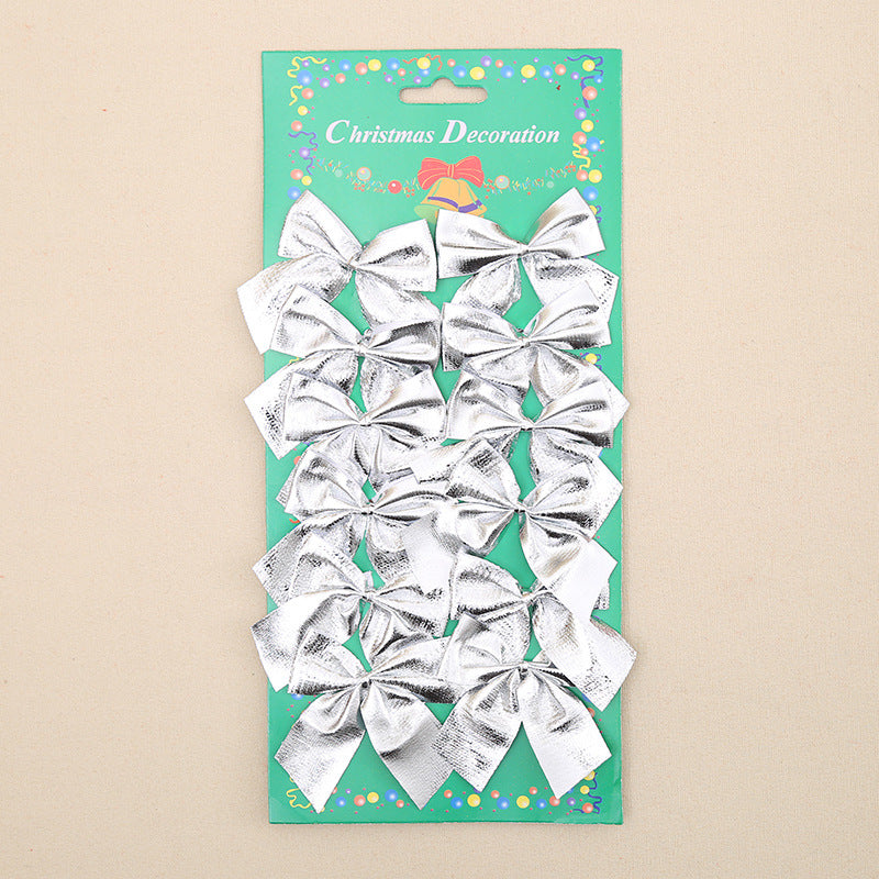 A pack of 12 silver bows on a green card labeled 'Christmas Decoration', featuring colorful confetti designs.