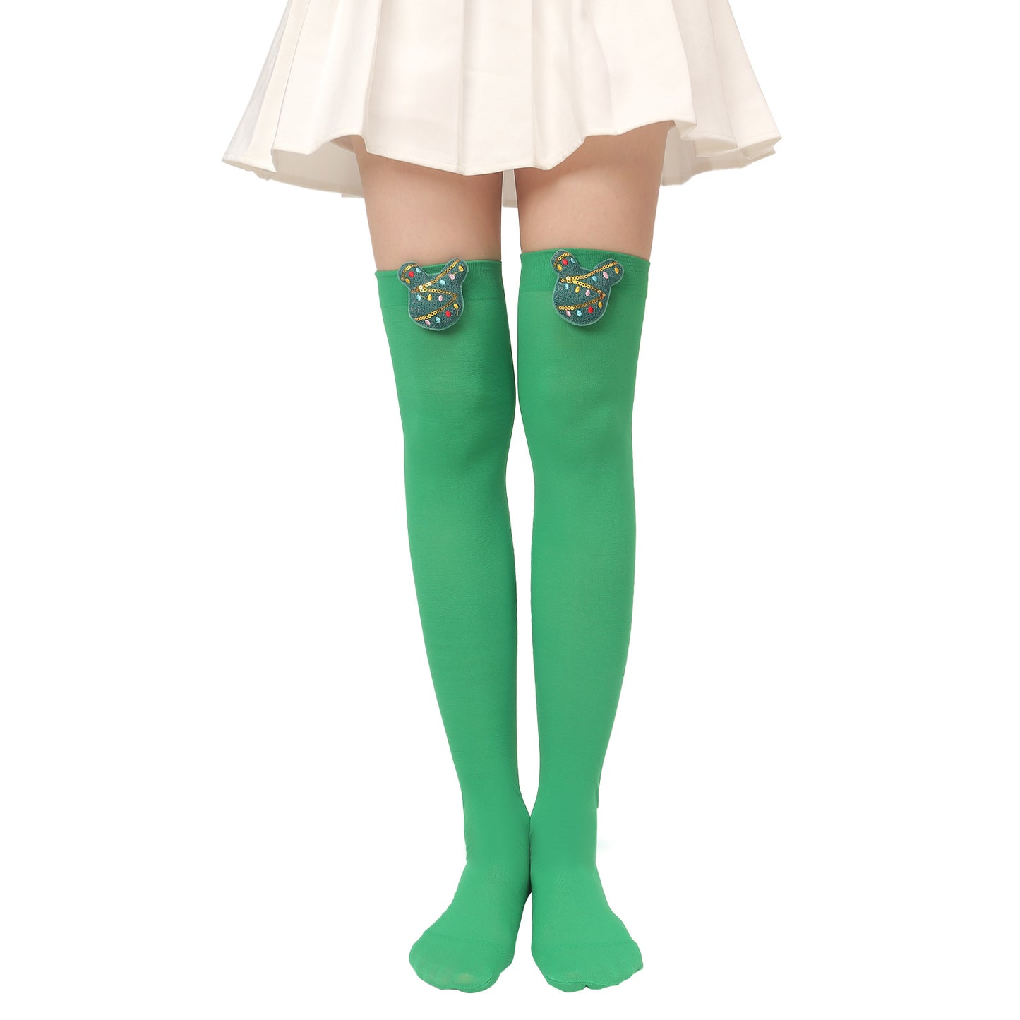 A person wearing knee-high green socks with cartoon face appliqués and a white pleated skirt, standing against a plain background.