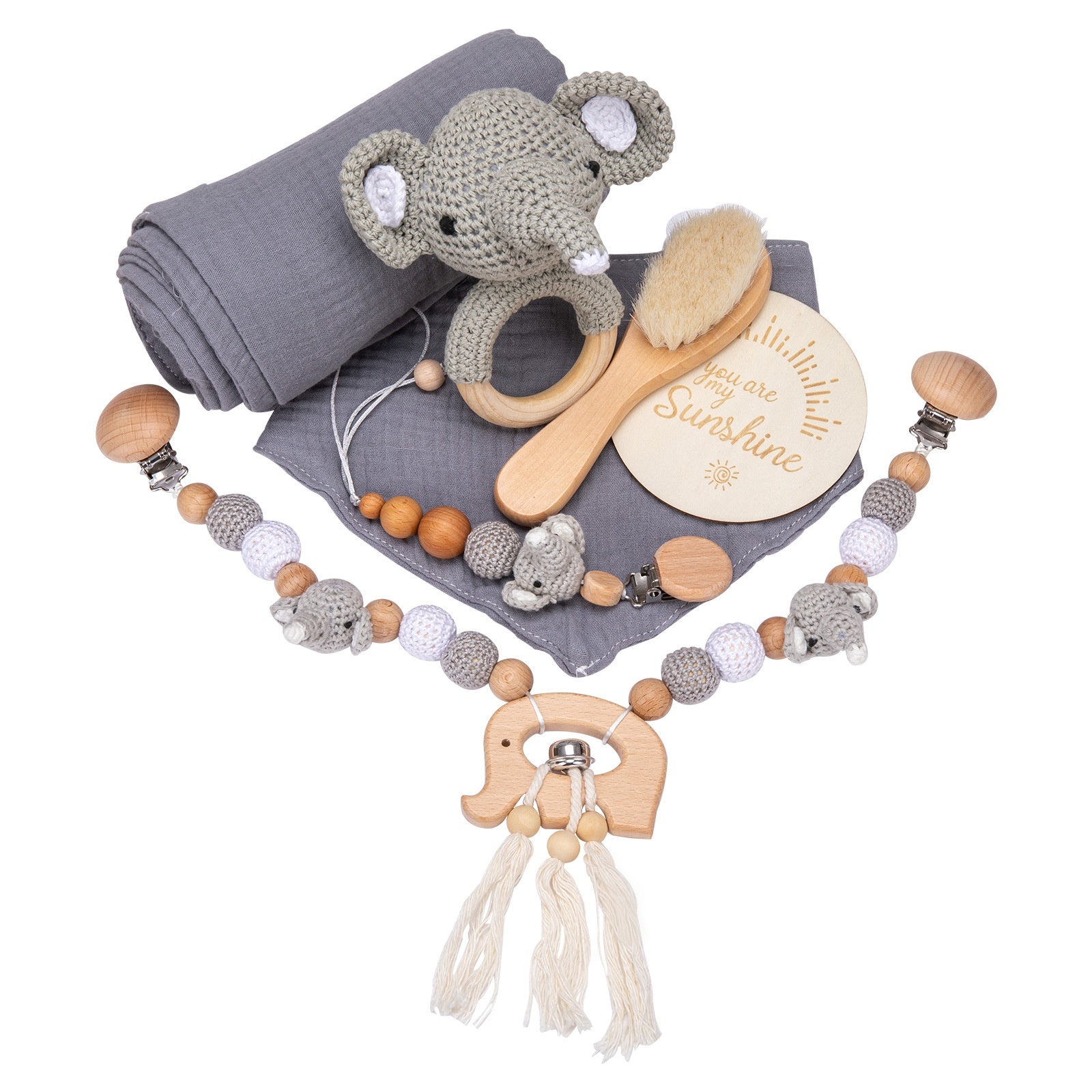 A baby gift set featuring a gray knit elephant rattle, wooden teething clip, natural brush, gray blanket, and a round plaque with "You are my sunshine" inscribed.