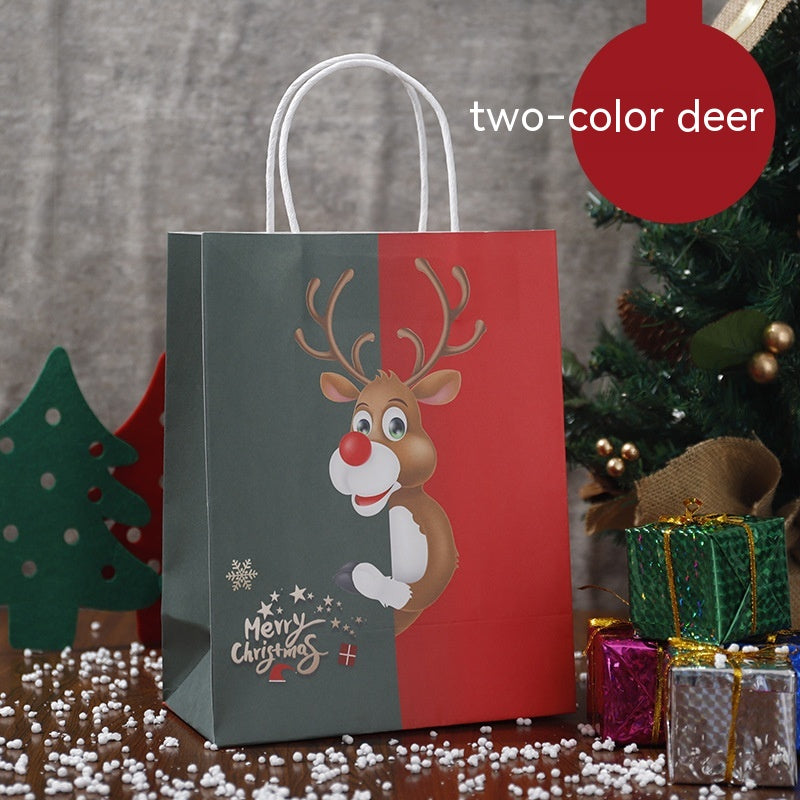 Festive gift bag with a cartoon reindeer, split design in red and green, alongside Christmas decorations, including a tree and wrapped presents, on a snow-speckled table.