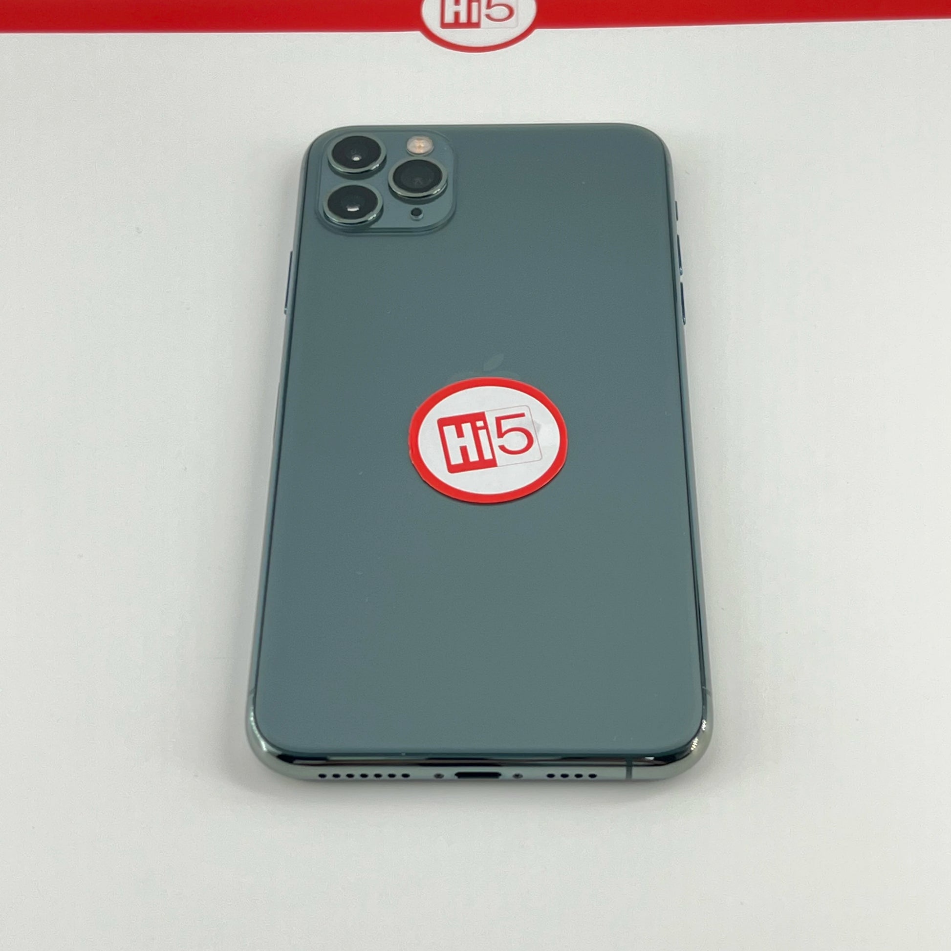 A smartphone with a triple camera setup is placed face-down. It has a circular "Hi 5" sticker on the back, and a similar logo is visible on a strip above.