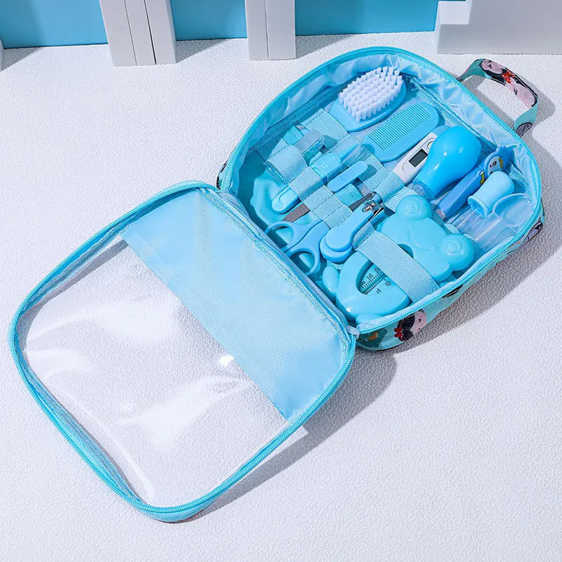 Light blue baby care kit with various grooming items, including scissors, a comb, brush, nail clippers, and a thermometer, neatly arranged inside a transparent, zippered case.