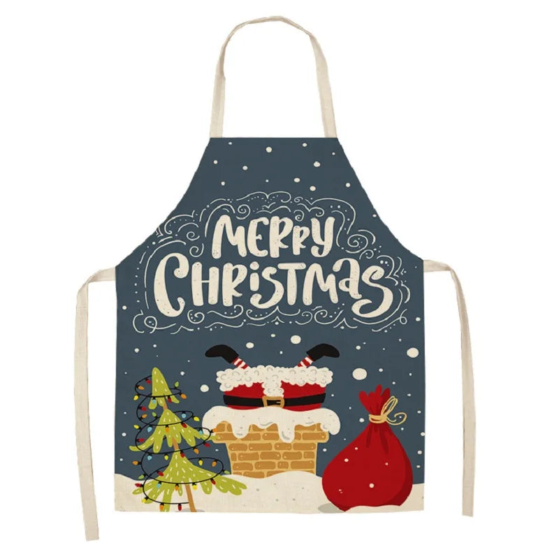 Christmas-themed apron featuring "Merry Christmas" text, Santa's legs in a chimney, a decorated tree, snowflakes, and a large red gift bag on a dark background.