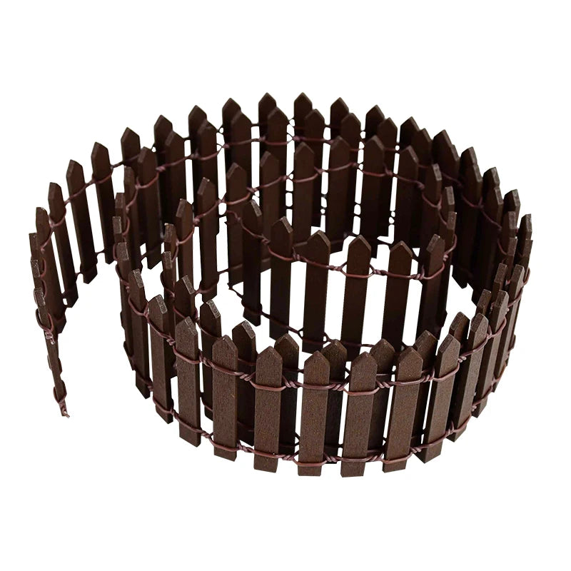 Brown plastic picket fence rolled in a coil. The fencing has pointed tops and is connected with wire loops, creating a circular shape suitable for garden or decorative use.