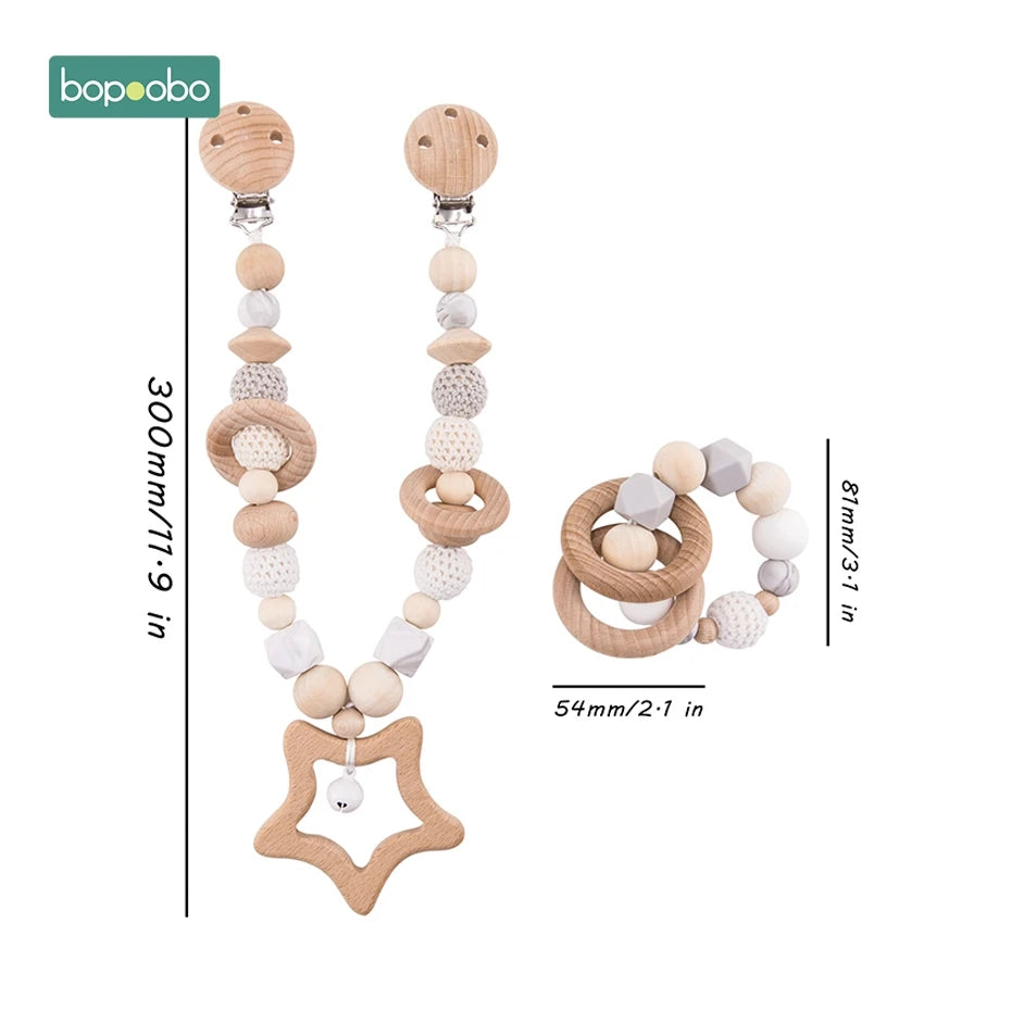 Wooden teething set with a star clip chain and round rattle. Chain measures 300mm/11.9in, rattle 81mm/3.1in, featuring wooden and crochet beads in neutral tones.