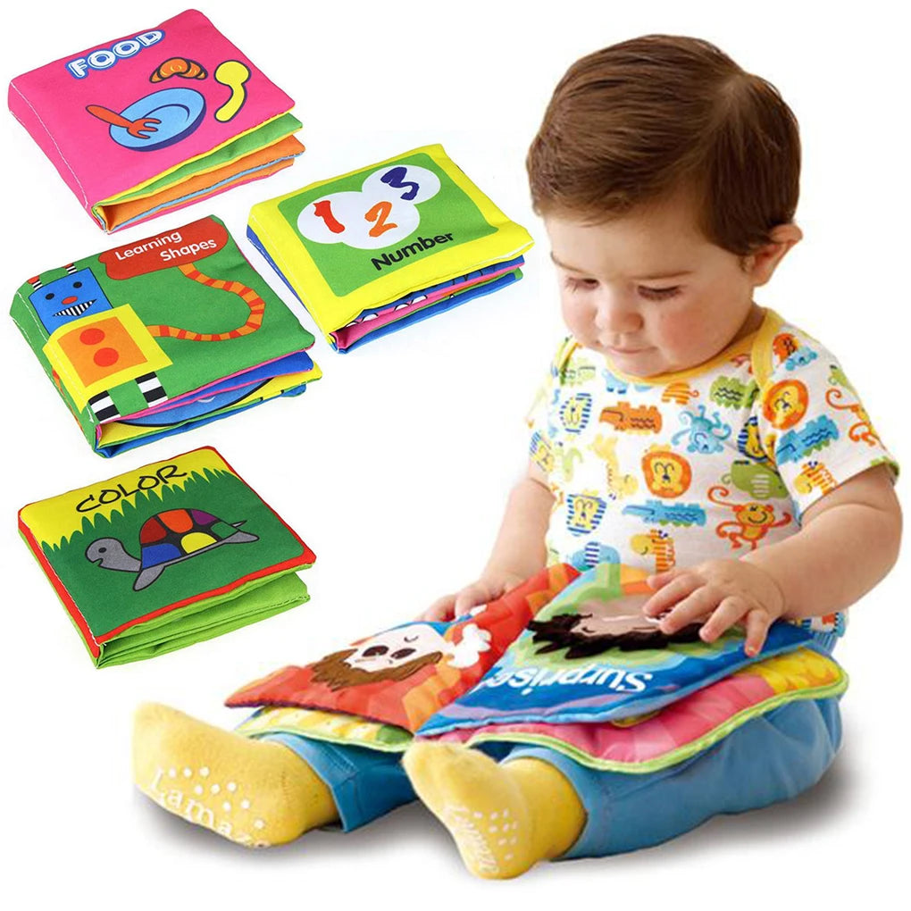 A child in a colorful shirt and yellow socks plays with a soft, colorful cloth book. Additional cloth books on food, numbers, shapes, and colors are spread nearby.