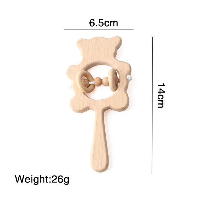Wooden bear-shaped baby rattle with handle, measuring 6.5cm by 14cm. Features two inner rings and weighs 26g.