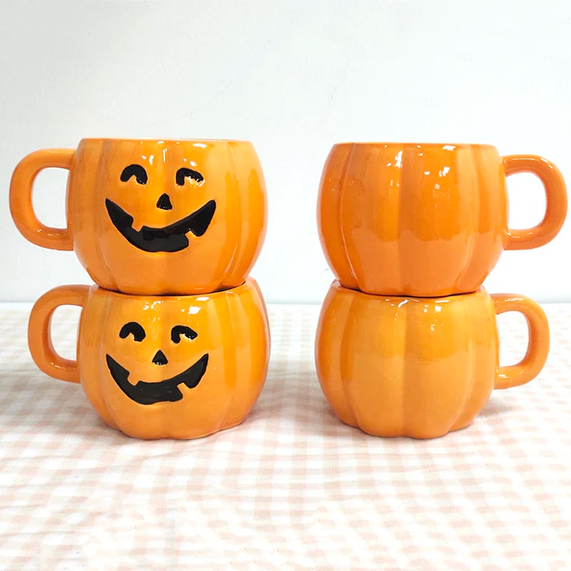 Four orange pumpkin-shaped mugs stacked in pairs on a checkered surface. Two mugs feature jack-o'-lantern faces while the others are plain.
