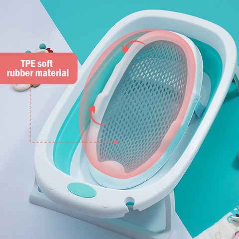 Collapsible baby bathtub with a blue mesh sling and soft pink TPE rubber material. The design is compact with smooth edges, suitable for small spaces.