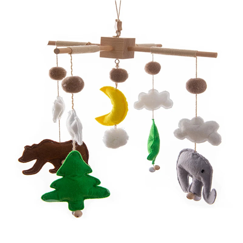 Baby mobile with felt shapes including a bear, tree, moon, clouds, and an elephant, hanging from wooden bars. Earth tones with a touch of yellow and green for contrast.