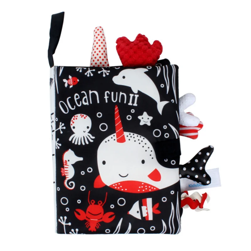 Soft sensory book titled “Ocean Fun II” with illustrations of marine animals like a narwhal, dolphin, and octopus, in black, white, and red, with textured tags.