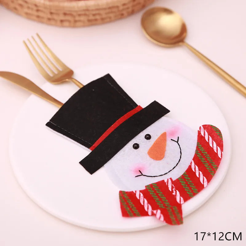 Festive cutlery holder shaped like a snowman with a black hat and red scarf on a white plate, accompanied by a gold fork and spoon. Size marked as 17*12CM.