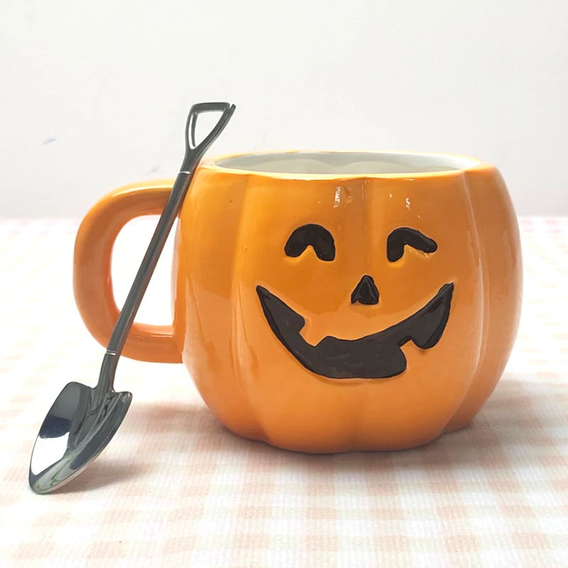Orange pumpkin-shaped mug with a smiling jack-o'-lantern face, paired with a small silver shovel-shaped spoon, set against a soft checkered background.