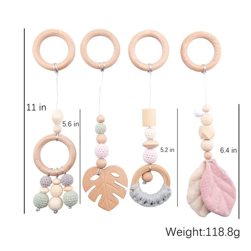 Four wooden baby gym toys, each suspended from a wooden ring with crochet beads and shapes, including leaves and rings. Heights range between 5.2 and 6.4 inches. Total weight: 118.8g.