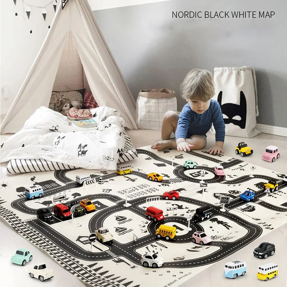 A child plays with toy cars on a black and white road map play mat in a cozy room with a teepee tent, cushions, and decorative bunting.