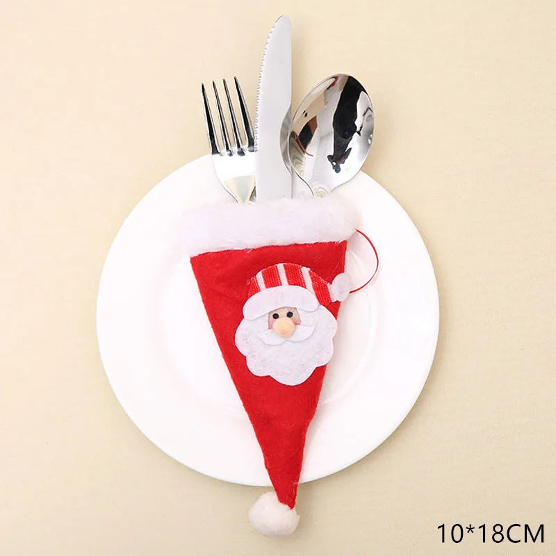Silver cutlery held in a red Santa-themed felt pouch, placed on a white plate. The pouch features a Santa face and measures 10 by 18 cm.